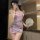 A woman poses elegantly in a nightwear set, featuring a delicate pink floral design. the ensemble combines a sheer silk blend...