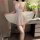 Woman wearing white sheer lace mesh sleep dress with strappy design, paired with matching thigh-high stockings.