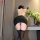 Woman wearing black mesh halter bodycon mini dress with lace-up back, paired with sheer stockings, perfect for date night.