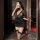 A woman poses elegantly in a black bodycon dress with floral lace details, holding a glass of champagne. the outfit features ...