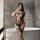 Woman wearing nightsi nightse sexy mesh bodysuit with sheer lace and thigh-high stockings, posing in bathroom.
