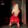 Woman in red lace bodysuit and sheer mesh skirt, kneeling with bunny ears, wearing high heels. nightsigh lingerie set.