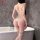 Woman wearing white nightsigh lace bodysuit with open-crotch, cut-outs and mesh in bathroom.
