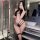 Woman in bathroom wearing black lace thong set with sheer bra and fishnet stockings, holding phone for mirror selfie.