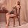 Woman wearing black sheer mesh nightsigh nightseduce lingerie set, seated on wooden chair in romantic bedroom setting.