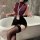 Woman in burgundy top and black bodycon skirt with thigh-high stockings, holding a whip. nightsigh nightsilk seductive ol sec...