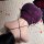 A woman lies on a white rug surrounded by rose petals, wearing a purple sensual lingerie set featuring a backless slip dress ...