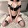 Woman wearing black and white striped night night lingerie set with crop top, mini skirt, and thigh-high stockings.