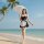 A woman strolls along the beach wearing a black and white maid costume set, complete with an underwire push-up bra and matchi...