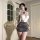 Woman in elegant ol secretary lingerie set with white lace top, gray mini skirt, and black bow choker.