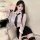 A woman wearing a sheer blouse with a black tie, paired with a tight pencil skirt and lace stockings, embodying an office sec...