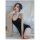 A woman poses wearing a black one-piece swimsuit, featuring thin straps and a scoop neckline, ideal for evening wear or theme...
