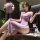 A woman wearing a purple lace maid outfit with off-the-shoulder design, sitting elegantly on a counter. the dress features in...