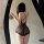 Woman wearing black peachy lace halter deep v sheer lingerie set with sensual cross-back design, posing in front of mirror.