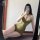 Woman wearing green peachy lace halter deep v sheer lingerie set - sensual cross-back erotic bodysuit for women, posing in mi...