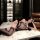 Woman lounging on marble table in pearl-embellished sensual open-crotch bodysuit — sexy, playful lingerie with lace trim and ...