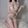 Woman wearing white pearl temptation lingerie set with lace bra, thong, and fishnet stockings on fluffy rug.