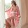 A woman poses elegantly in a pink cherry blossom kimono robe, featuring sheer satin lace details. the flowing design exudes r...