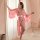 A woman stands gracefully beside sheer curtains, wearing a pink cherry blossom kimono robe made of sheer satin lace. the eleg...