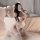 Woman in pink cat maid bodysuit with open bust and crotch, wearing fishnet stockings and fluffy paws, posing seductively on b...