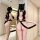 Woman wearing a plus size catwoman costume set with a black tail, kitten ears, and sexy lingerie in front of a mirror.