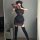 Woman wearing a plus size chinese style cheongsam lingerie set with apron, holding a fan in a retro maid dress outfit.