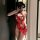 A woman poses in a red sheer nightgown featuring intricate cloud brocade patterns and butterfly knot details, capturing a sen...