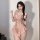 Woman wearing pink floral lace bodysuit with deep v neckline and built-in pads, featuring open-crotch design and ruffled hem.