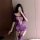 Woman in purple sheer bodysuit with ripped thigh highs, holding phone for mirror selfie.