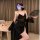 A woman poses elegantly in a black lace bralette sleep set, featuring sheer cami and shorts with floral details. she holds a ...