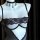 Black lace bodysuit with push-up cups and open crotch, paired with a choker necklace, displayed on a mannequin.
