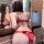 Woman in red lace lingerie set with open-crotch design and side ties, shown from back view in mirror reflection.