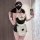 Woman wearing black and white plus size maid costume with apron, bow tie, and heart details, holding phone for selfie.