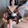 A woman wears a plus-size seductive geisha kimono-inspired erotic costume, featuring a low neckline and floral patterns, perf...