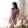 A woman models a sheer, lavender-colored sleepwear set with lace detailing and a tie-front design, perfect for sensual nightw...