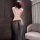 Woman wearing plus size sensual lingerie set with sheer black skirt and gold trim, elegant sleepwear for bedroom intimacy.