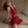 Woman in red deep v-neck sleep dress with sheer mesh back, lying on bed — plus size sexy lingerie set for pure & tempting nig...