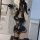 Woman wearing black lace corset bodysuit with underwire, sheer panels, garter straps, and gloves, taking mirror selfie in sty...