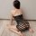 Woman wearing plus size sexy lace fishnet bodystocking with open-crotch design, sitting on floor.