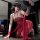Woman in red lace sleep dress with sheer mesh and embroidery, holding a black fan—vintage style for date night.