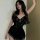 Woman wearing black lace sleepwear set with sheer details and scalloped edges, designed for plus size figures.