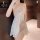 Woman wearing white lace sleepwear with deep v neckline and thin straps, featuring a bow detail at the front.