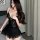 Woman wearing black lace sleepwear dress with sheer panels and flared hem, styled for intimate nights.