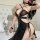 Woman wearing black sheer lingerie set with gold chains, featuring cutouts and a seductive robe design for plus size.