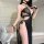 Woman wearing a black sheer plus size sexy lingerie set with gold chains, featuring a cutout robe and high slit for a seducti...