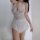 Curvy woman in white lace bodysuit with sheer mesh and open-crotch design, perfect for romantic bedroom moments.