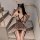 Woman wearing plus size leopard print lingerie set with cat ears, bodycon dress, gloves, and striped stockings on stairs.