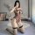 Woman kneeling in leopard print one-piece lingerie set with fishnet stockings, holding phone for mirror selfie.