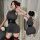 Woman modeling midnight chic high-neck mini dress with lift-up bust, waist belt, and red garter stockings.