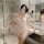 Woman in bathroom wearing sheer white princess-style lingerie set with mesh cami and shorts, flirty plus size sleepwear for s...